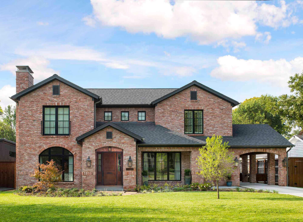 Brick luxury custom home exterior with arched entryway in Dallas, TX
