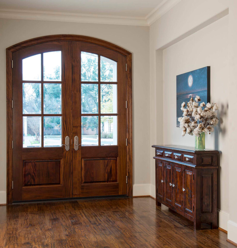 Arched wood double front doors in luxury custom home entry in Dallas, TX