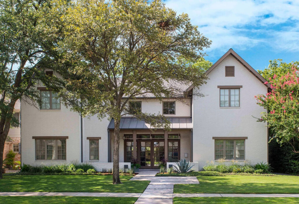 Transitional custom home exterior with white stucco and dark window trim in Dallas, TX