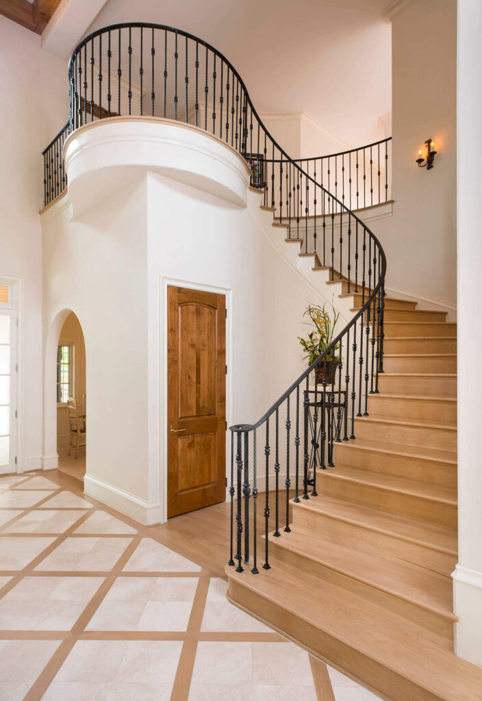 Grand curved staircase with iron railing in luxury custom home in Dallas, TX