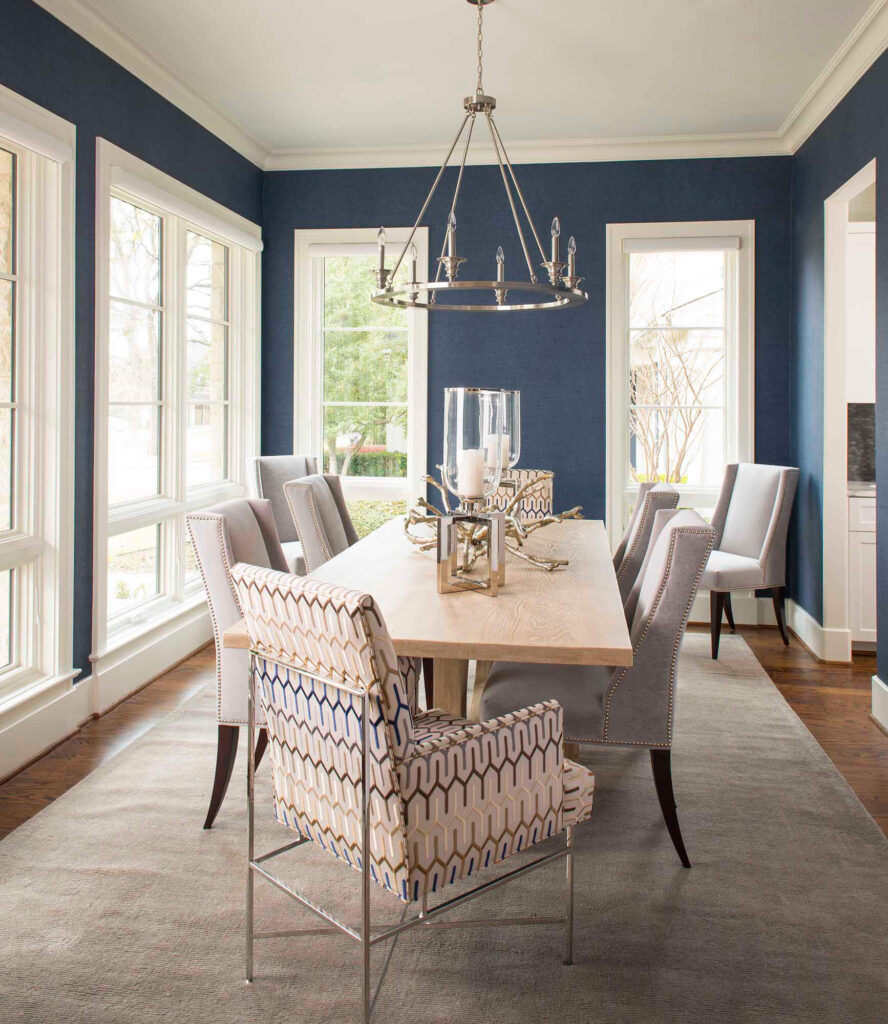 Formal dining room with navy walls and chandelier in Dallas custom home