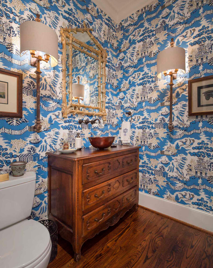 Powder bathroom with blue patterned wallpaper and wood vanity in Dallas, TX