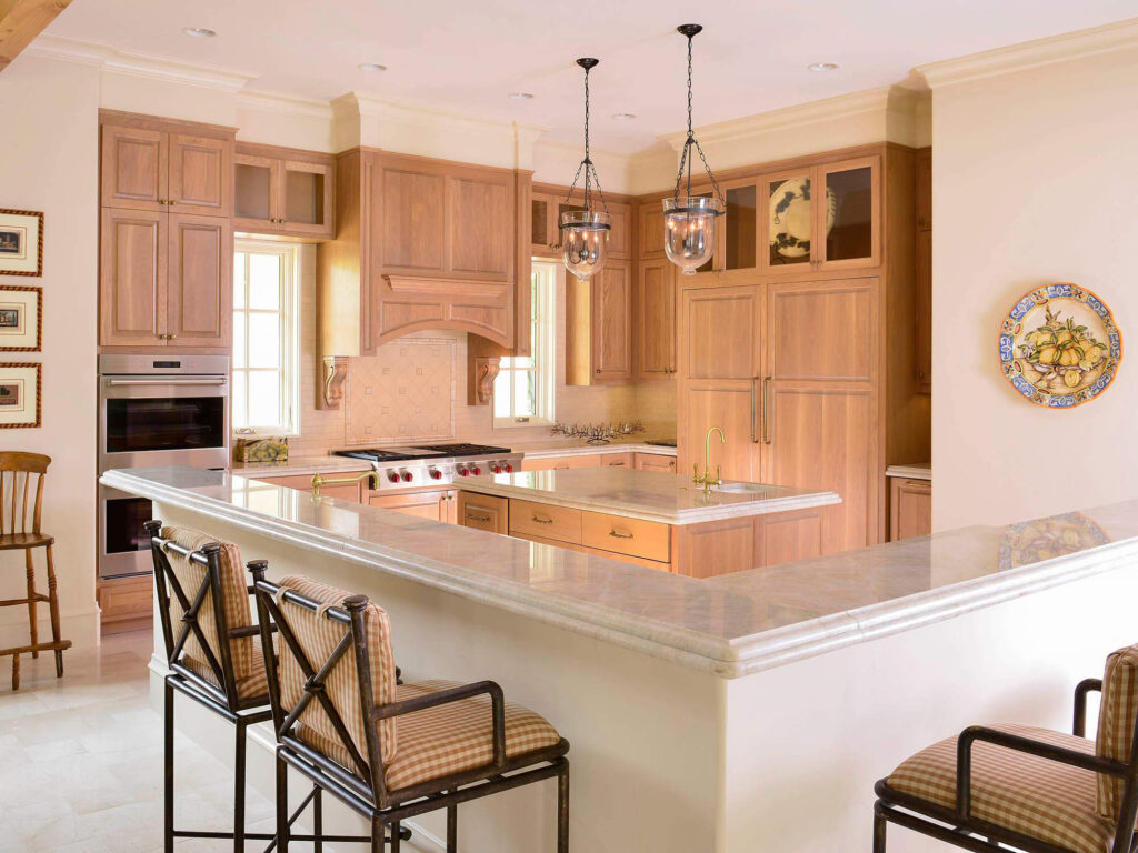 Light wood kitchen with large island and pendant lighting in Dallas
