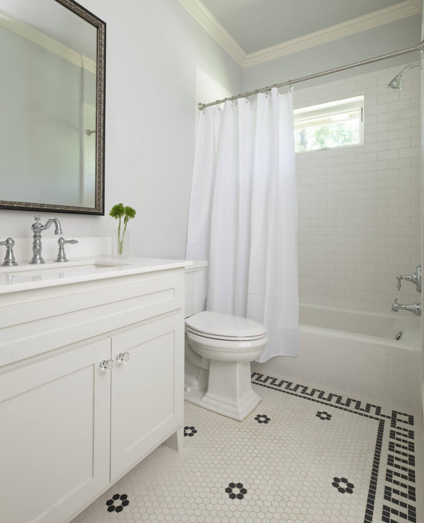 Classic white bathroom with shower curtain and patterned tile floor in Dallas, TX