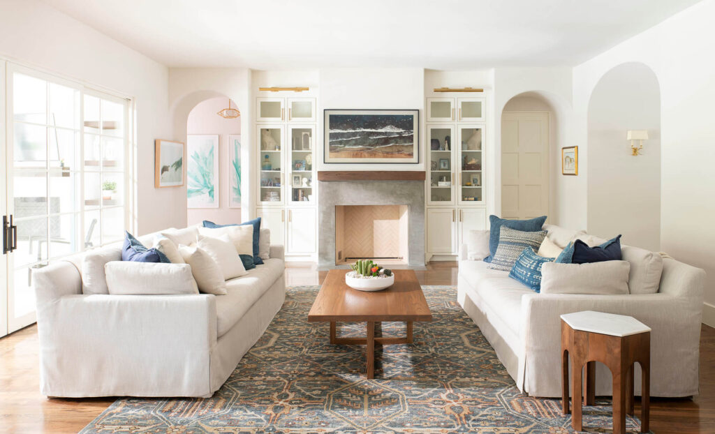 Luxury custom home living room with white sofas and fireplace in Dallas, TX
