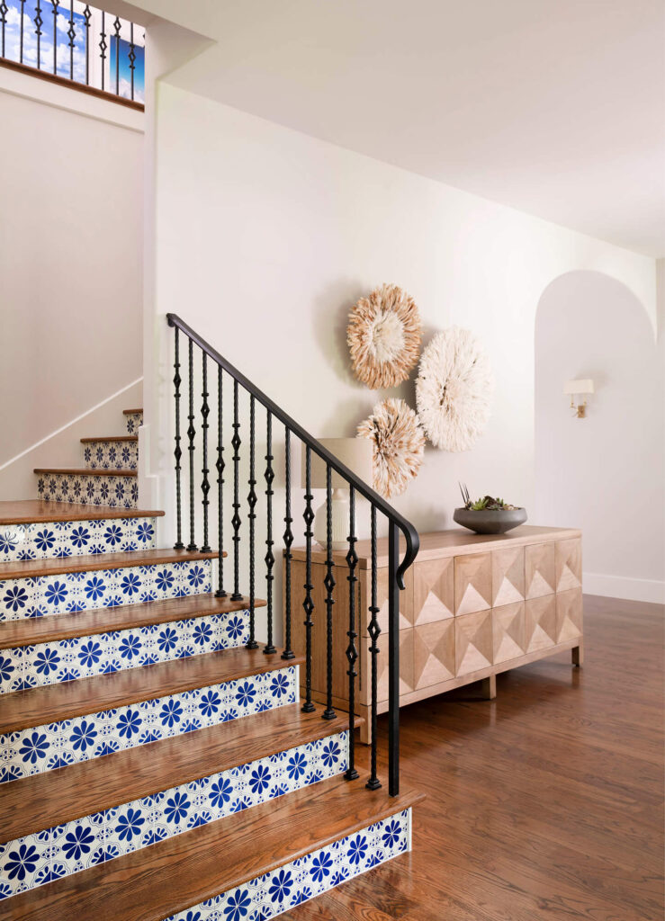 Tile staircase with iron railing in luxury custom home entryway in Dallas, TX