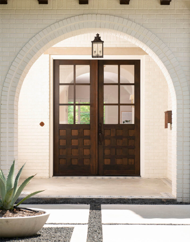 Arched brick entry with wood double doors in Dallas luxury home