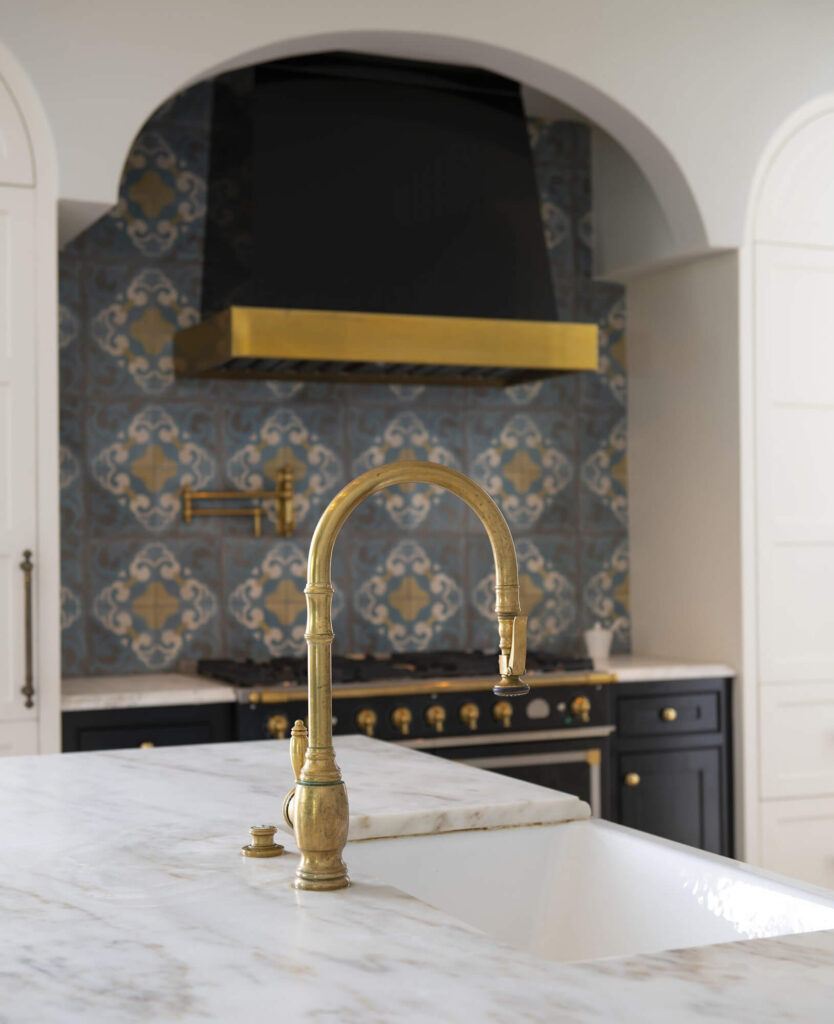 Luxury kitchen range alcove with patterned tile and brass accents in Dallas