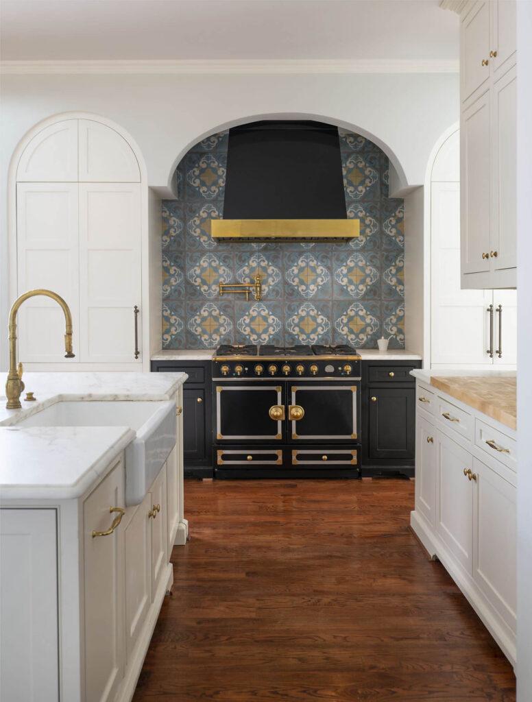 Luxury kitchen with arched tiled range alcove and brass accents in Dallas, TX