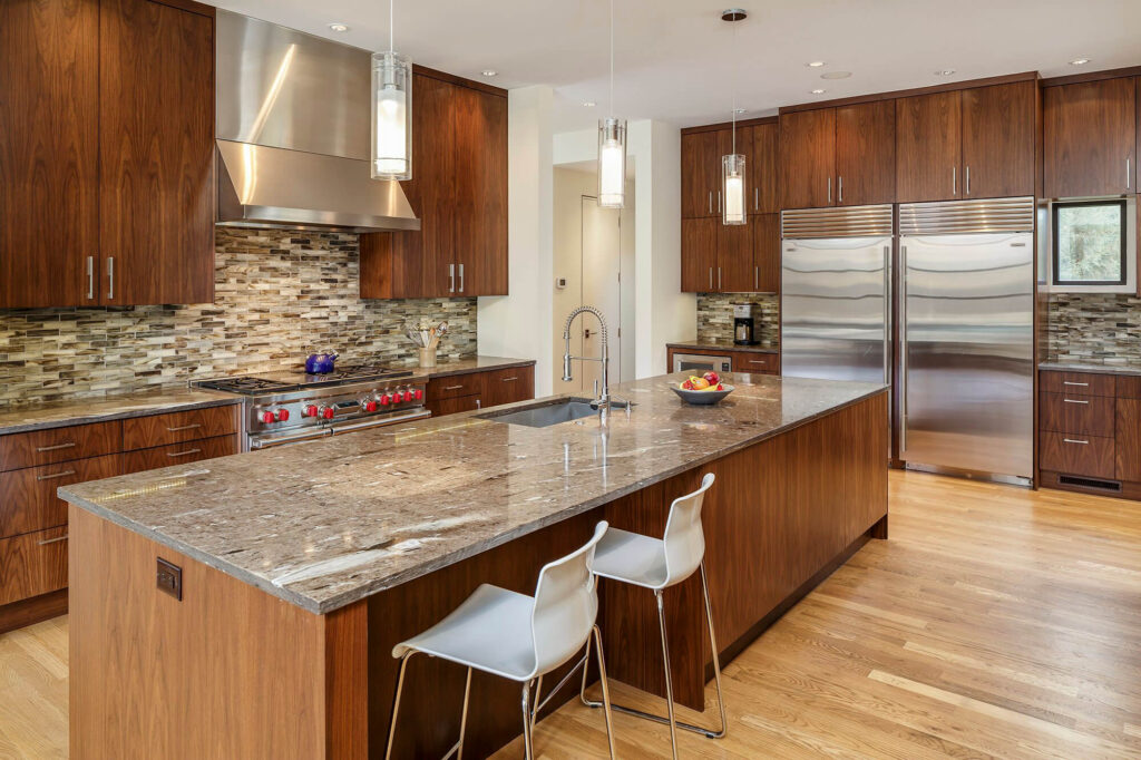 Contemporary kitchen with large stone island and wood cabinetry in Dallas, TX