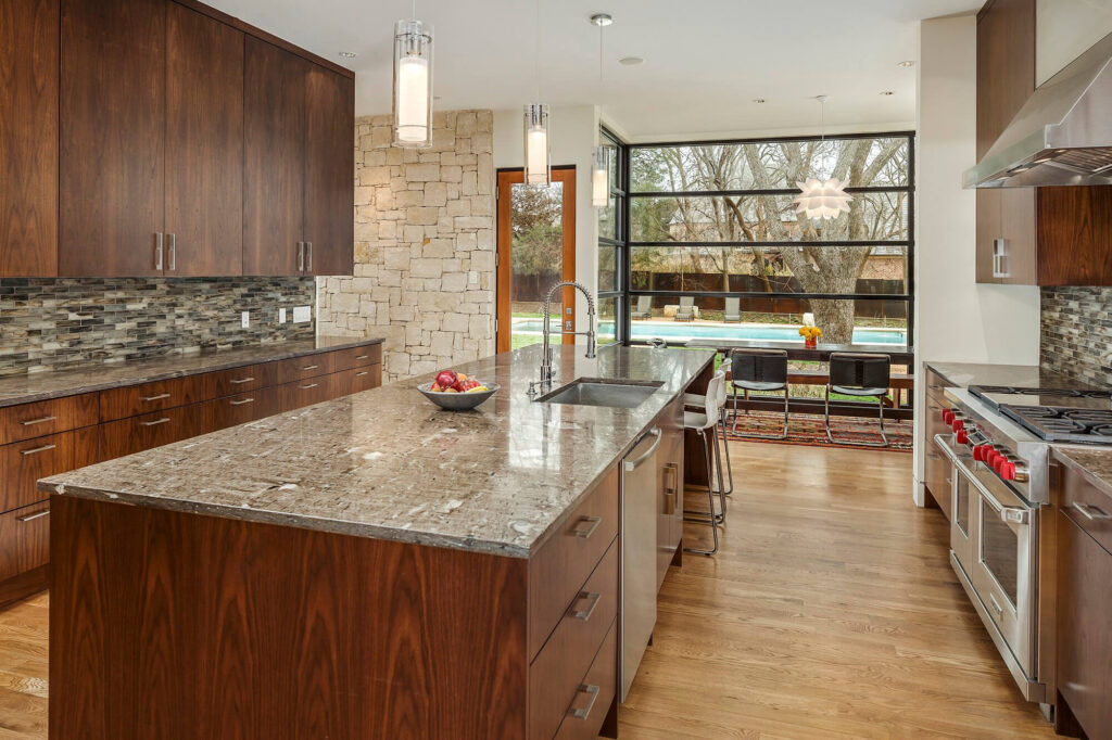 Modern kitchen with granite island and wood cabinetry in Dallas, TX