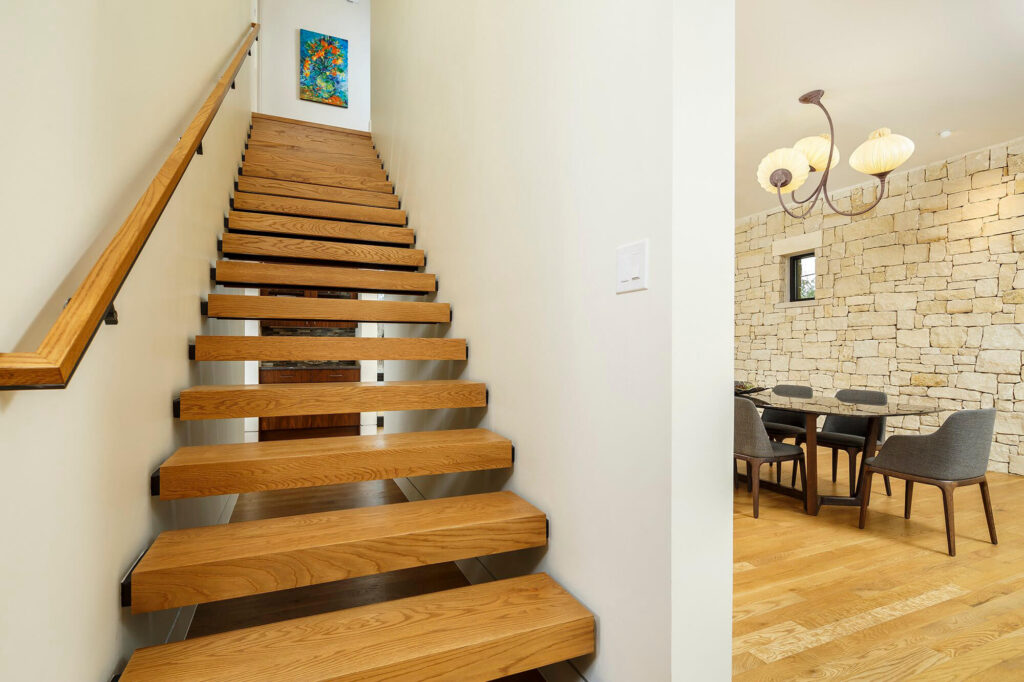 Floating wood staircase with open risers in Dallas contemporary home