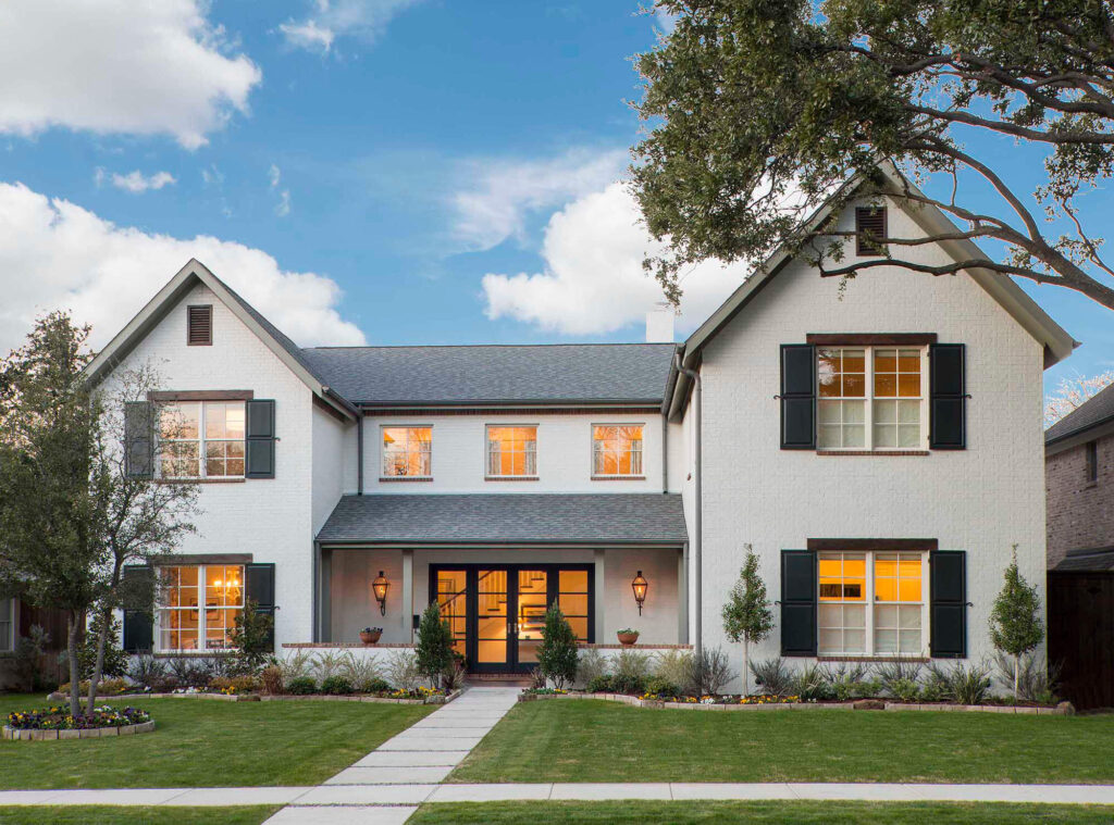Traditional custom home exterior with shutters and front walkway in Dallas, TX