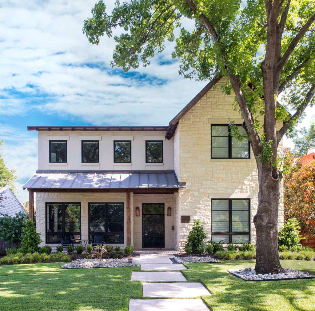Two-story custom home with light stone exterior and metal awnings in Dallas, TX