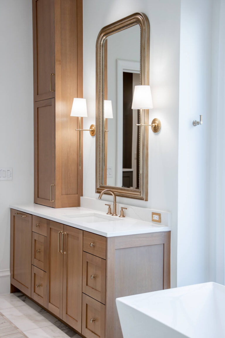 Brunswick vanity with brass sconces and custom millwork in Midway Hollow home