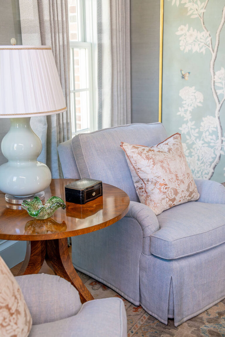 Custom living room vignette with round wood table and blue armchair in Dallas home