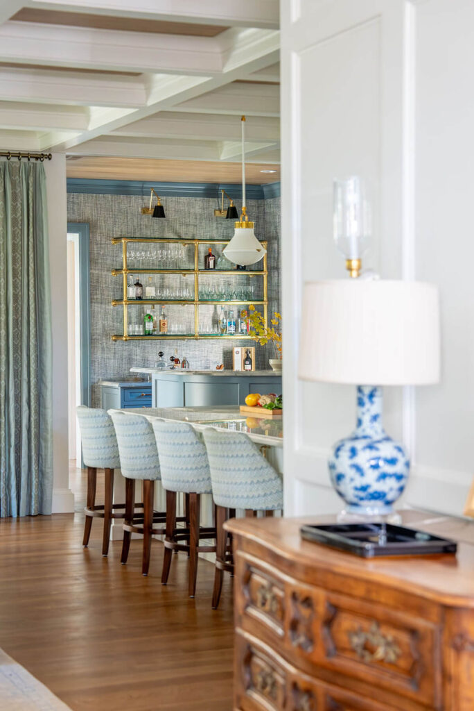Custom blue and brass bar with glass shelves in Dallas transitional kitchen