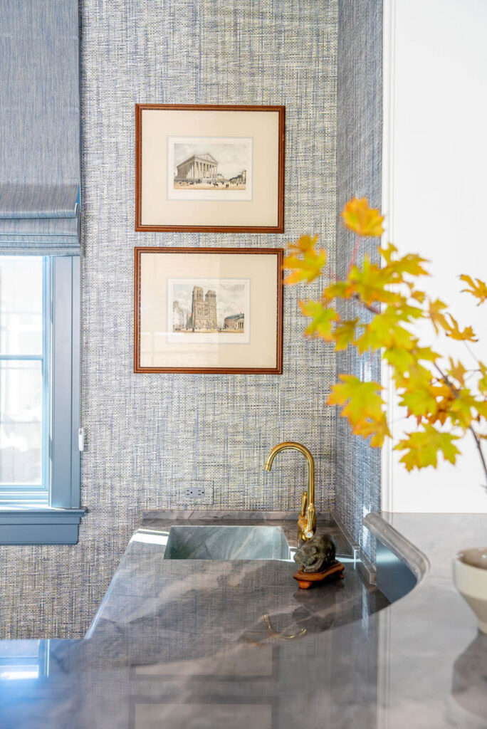 Blue tile wet bar with brass faucet and framed art detail