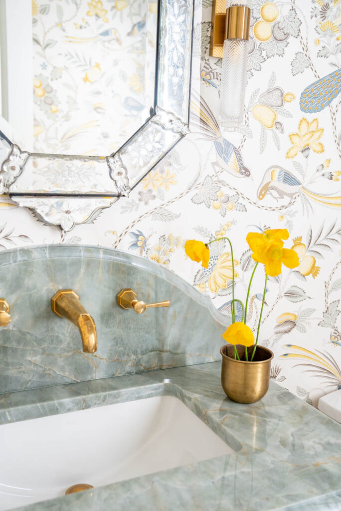 Custom bathroom sink with floral wallpaper and brass fixtures
