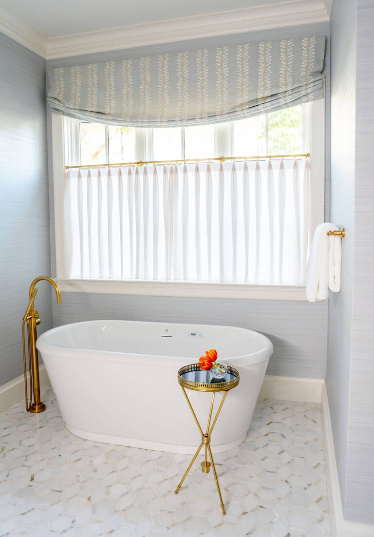 Freestanding soaking tub with brass fixtures in Dallas bathroom