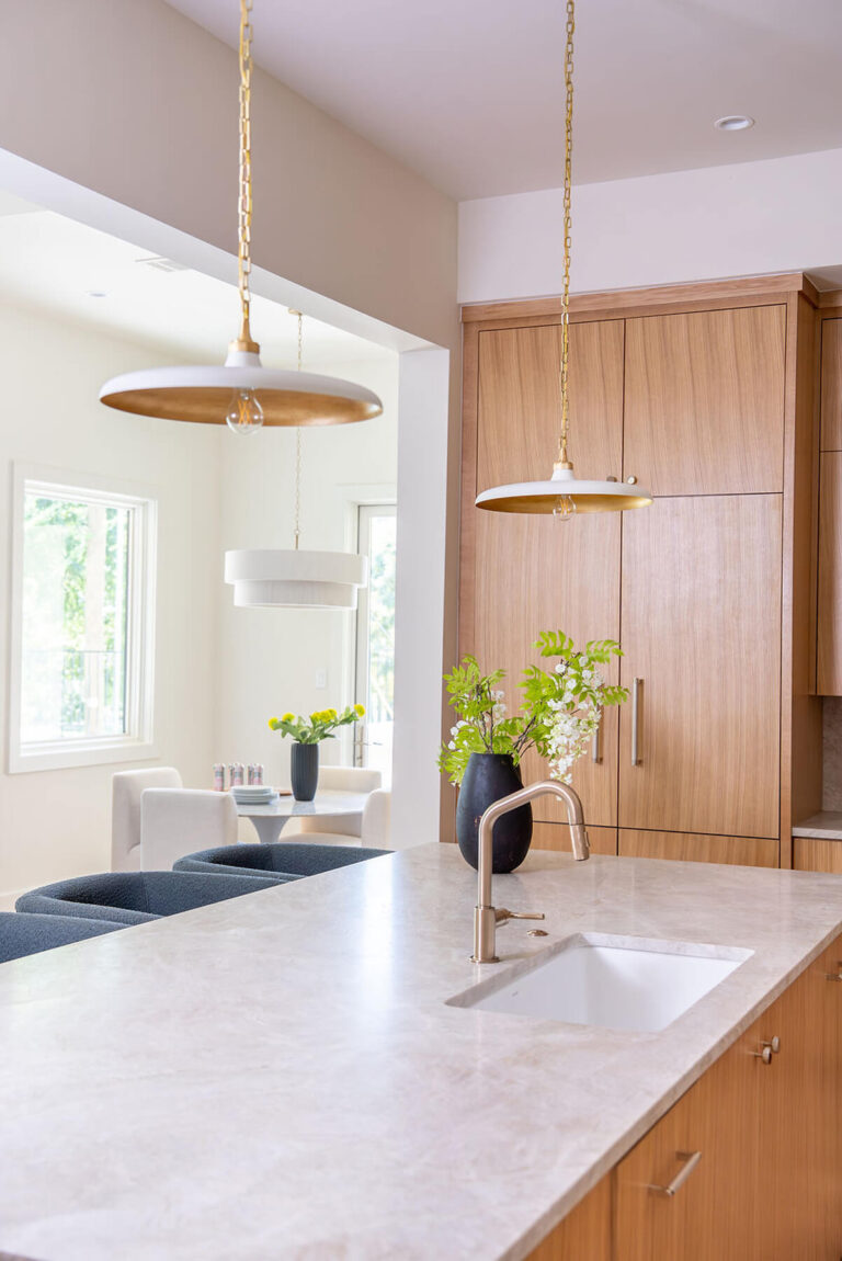 Lyre Lane kitchen view with brass pendant lighting and wood cabinetry in Dallas home
