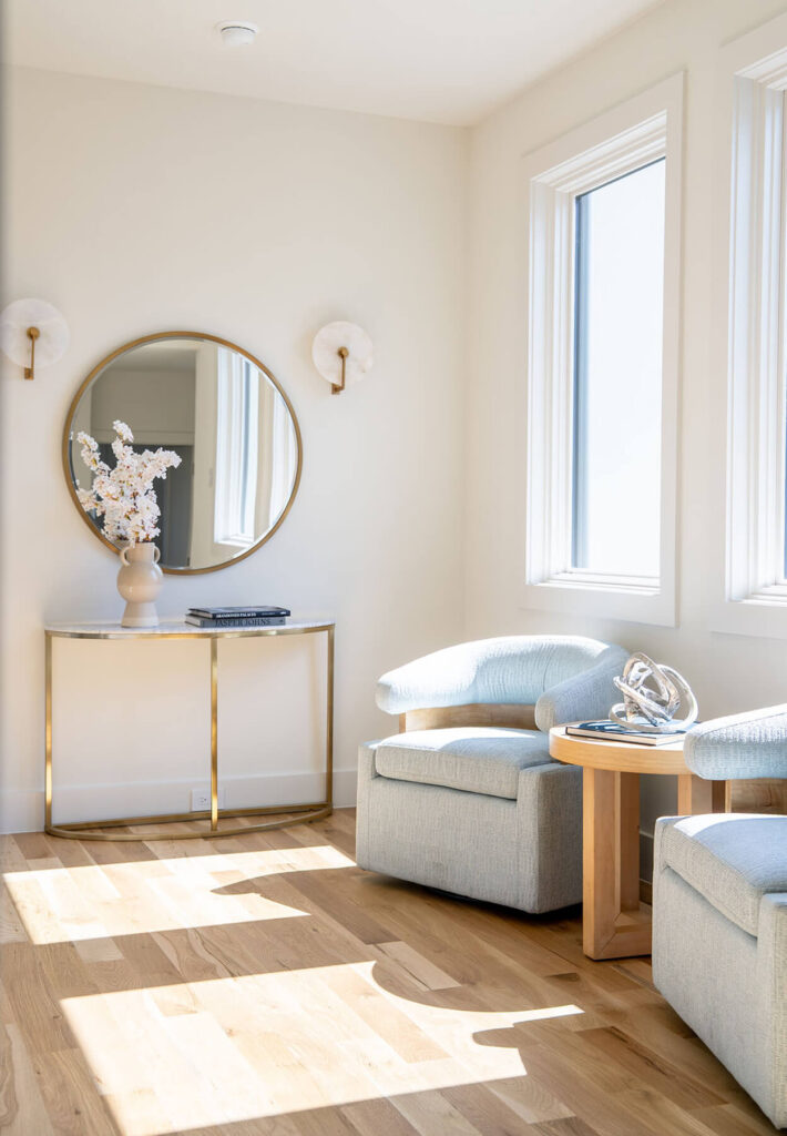 Lyre Lane entry vignette with round mirror and upholstered bench in Dallas home