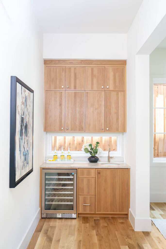 Lyre Lane custom bar area with light wood cabinetry and wine fridge in Dallas home