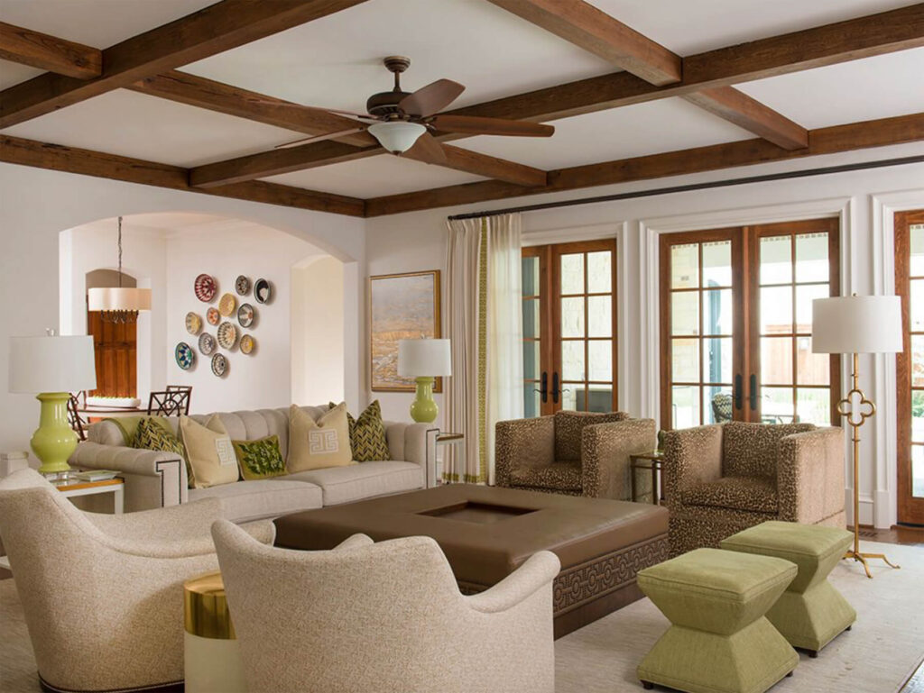 Custom living room with exposed wood beam ceiling, French doors, and neutral seating by Creekview Custom Homes