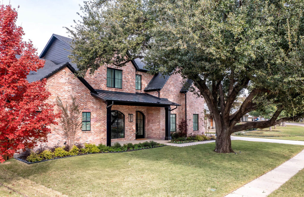 Brunswick custom transitional brick home exterior in Midway Hollow Dallas with black metal roof